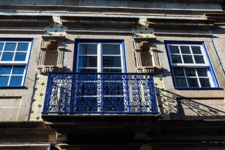 Foto de Fachada de un antiguo edificio clásico con barandilla de hierro forjado azul en el casco antiguo de Braga, Portugal - Imagen libre de derechos