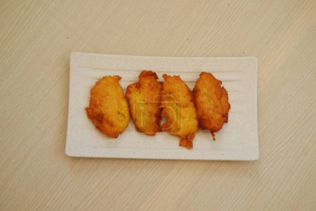 Corn croquettes on a white plate on a wooden table