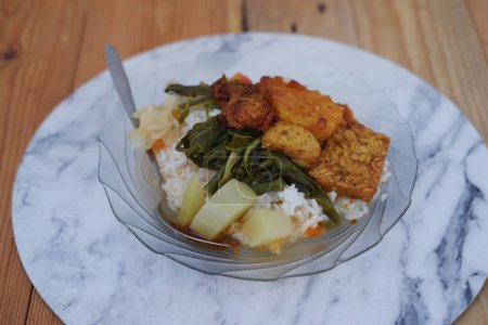 Reis mit gebratenem Huhn und Gemüse auf einem Teller in einem Restaurant