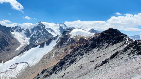 Foto de Picos de montaña nevados. Hermoso paisaje de verano de montaña. Increíble vista de la montaña alrededor del Pico Komsomolets, Parque Nacional Ala-Archa, Kirguistán. Vista desde lo alto de las majestuosas montañas kirguisas. - Imagen libre de derechos
