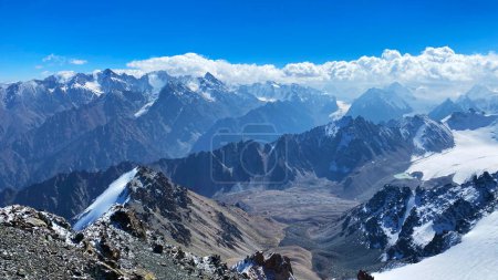 Foto de Increíble vista desde la cima del Monte Adygen. Parque Nacional Ala-Archa, Kirguistán. Montañas nevadas, rocas, laderas y picos de la cordillera kirguisa. Vacaciones activas en Asia. - Imagen libre de derechos