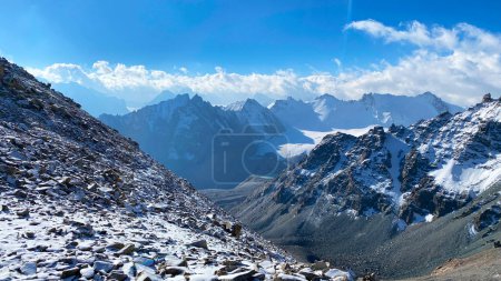 Foto de Mañana en las montañas. Un hermoso paisaje con montañas nevadas, rocas, pendientes y picos de la cresta kirguisa. Parque Nacional Ala-Archa, Kirguistán. Vacaciones activas en Asia. - Imagen libre de derechos