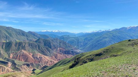 Majestic panorama of mountain peaks. Konorchek canyons in Kyrgyzstan. The mountains in the distance are covered with snow, and the sky is blue and clear. Trekking in the mountains