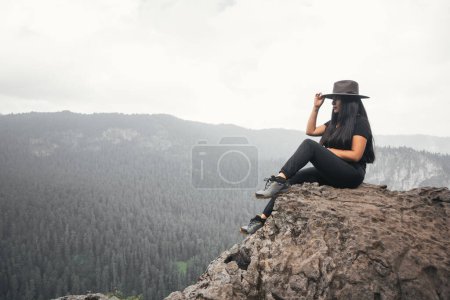 Foto de Mujer joven con sombrero observando el paisaje de montaña - Imagen libre de derechos