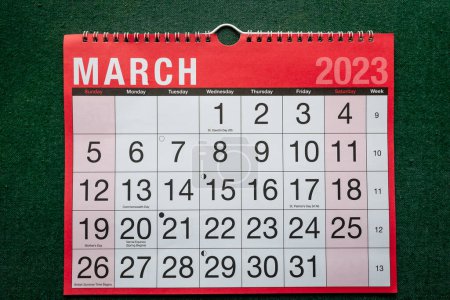 Calendar 2023, March, monthly planner. Day, month, year, date and activity organiser wall and desk planner. Red and white calendar with large letters and numbers on green background. 
