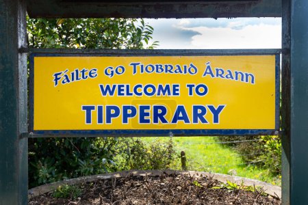 Foto de Tipperary, Irlanda, 13 abr 2023: Bienvenido a Tipperary señal de entrada de cerca fuera de Tipperary Town, Irlanda en 13 abr 2023. Traducción del irlandés incluido en el signo. - Imagen libre de derechos
