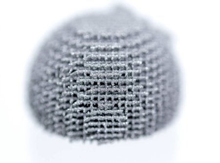 Foto de La superficie del objeto impreso en la impresora 3D para macro metal. Vista de cerca del modelo impreso a partir de polvo de metal en la impresora 3D. Nuevas tecnologías aditivas precisas y modernas. Modelado de tecnología de impresión 3D - Imagen libre de derechos