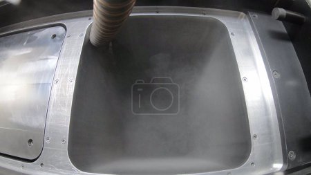 Foto de Verter polvo de metal en la superficie de trabajo de la impresora 3D para metal. Polvo de metal que fluye dentro de la impresora 3D para metal. Cámara de trabajo de llenado con polvo. SLM. Tecnología selectiva de fusión láser. - Imagen libre de derechos