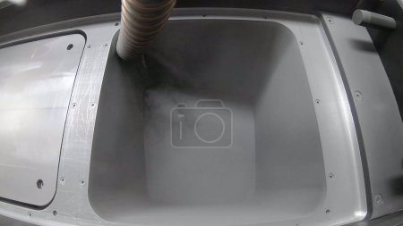 Foto de Pouring metal powder into working surface of 3D printer for metal. SLM. Selective laser melting technology. Flowing Metal Powder inside 3d printer for metal. Filling working chamber with powder. - Imagen libre de derechos