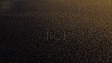 Photo for Landscape of plowed up land on an agricultural field on a sunny autumn day. Flying over the plowed earth with black soil. Agrarian background. Black soil. Ground earth dirt priming aerial drone view. - Royalty Free Image