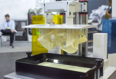 Foto de Modelos impresos en el primer plano de la impresora 3D. Objetos impresos en la impresora fotopolímero sla 3D a partir de resinas fotopolímeros líquidos en la plataforma de impresión. Tecnología moderna de aditivos progresivos. Impresión de impresora 3D - Imagen libre de derechos