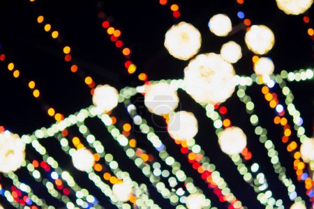 Foto de Gran árbol de Navidad de Año Nuevo decorado con luminosas guirnaldas multicolores e iluminación por la noche. Árbol de Navidad con luces intermitentes. Fondo borroso. Vacaciones de Año Nuevo y Navidad - Imagen libre de derechos