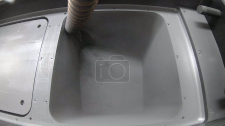 Foto de Pouring metal powder into working surface of 3D printer for metal. Flowing Metal Powder inside 3d printer for metal. Filling working chamber with powder. Selective laser melting technology. SLM. - Imagen libre de derechos