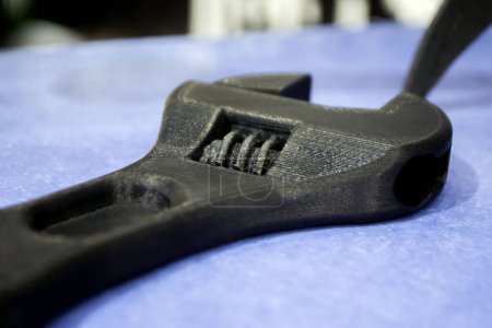 Foto de Modelo prototipo de una llave inglesa ajustable de plástico negro impreso en una impresora 3D. Concepto Impresora 3D, impresión 3D, modelado de prototipos de objetos tridimensionales. Producción aditiva innovadora - Imagen libre de derechos
