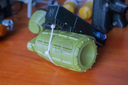 Foto de Modelo prototipo de munición granada impresa en impresora 3D. Pequeños modelos de granada arma defensiva impresa en la impresora 3D de plástico fundido en la mesa. Nueva tecnología de impresión de innovación moderna - Imagen libre de derechos