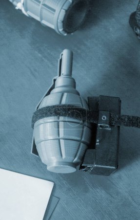 Foto de Modelo prototipo de munición granada impresa en impresora 3D. Pequeños modelos de granada arma defensiva impresa en la impresora 3D de plástico fundido en la mesa. Nueva tecnología de impresión de innovación moderna - Imagen libre de derechos