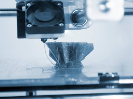 The process of printing an object with 3D printer. 3D printer printing a model from molten plastic. 3D printing. Robotic creation of mold form. Automated creation prototyping of 3D printers technology
