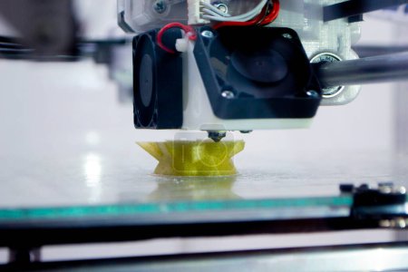The process of printing an object with 3D printer. 3D printer printing a model from molten plastic. 3D printing. Robotic creation of mold form. Automated creation prototyping of 3D printers technology