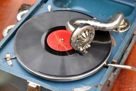 Un vieux disque rétro jouant sur un vieux gramophone vintage au marché aux puces. Travail de gramophone portable. Vieux tourne-disque vintage, phonographe, potefone. Aiguille de près. Plaque tournante antique nostalgie