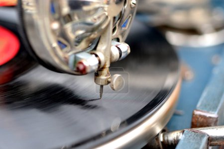 Un viejo disco retro tocando en un viejo gramófono vintage en el mercadillo. Trabajo de gramófono portátil. Antiguo tocadiscos, fonógrafo, potefone. Aguja de cerca. Giradiscos antiguos de nostalgia