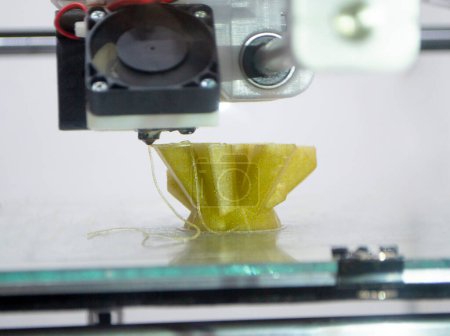 3D printer prints an object. The process of printing model on 3D printer. Model printed on 3D printer from molten plastic. 3D printing technologies. Additive progressive new modern printing technology