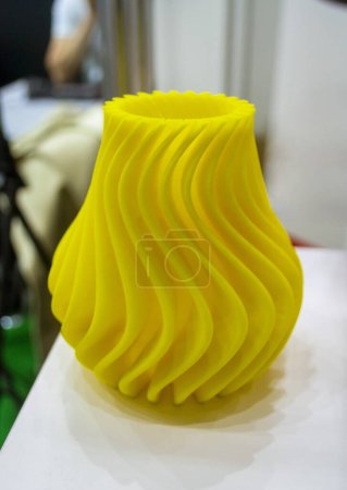Abstract art object printed on 3D printer. Colored yellow creative model printed on 3D printer from molten ABS PLA plastic filament. Object printed FDM printer. Additive progressive modern technology