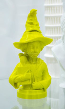 Abstraktes Kunstobjekt, gedruckt auf 3D-Drucker. Farbiges gelbes kreatives Model Mädchen mit Hut, gedruckt auf einem 3D-Drucker aus geschmolzenem ABS-PLA-Kunststoff-Filament. Objekt gedruckter FDM-Drucker. Additiv-moderne Technologie