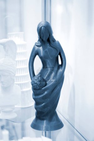 Abstract art object printed on 3D printer. Colored creative model printed on 3D printer from molten ABS PLA plastic filament. Object blue figurine of woman and child printed on FDM printer. Additive