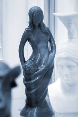 Abstraktes Kunstobjekt, gedruckt auf 3D-Drucker. Farbiges, kreatives Modell gedruckt auf 3D-Drucker aus geschmolzenem ABS-PLA-Kunststoff-Filament. Objekt blaue Figur von Frau und Kind auf FDM-Drucker gedruckt. Additiv