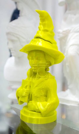 Abstraktes Kunstobjekt, gedruckt auf 3D-Drucker. Farbiges gelbes kreatives Model Mädchen mit Hut, gedruckt auf einem 3D-Drucker aus geschmolzenem ABS-PLA-Kunststoff-Filament. Objekt gedruckter FDM-Drucker. Additiv-moderne Technologie