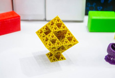 Objeto amarillo abstracto impreso en impresora 3D. Objeto de forma geométrica abstracta creado por la impresora 3D. Prototipo detallado impreso en primer plano de la impresora 3D. Nuevas tecnologías modernas de impresión 3D aditiva