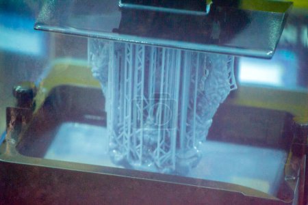 Proceso de impresión 3D SLA. Impresión de procesos en impresora 3D mediante tecnología de impresión SLA. Objeto impreso en 3D de polimerización de resina. Objeto creado en impresora 3D a partir de resina endurecida. Tecnología de impresión