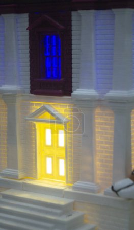 Foto de Prototipo impreso en el edificio de ladrillo de la impresora 3D con columnas y ventanas brillantes. Modelo de construcción con color blanco y marrón, ventanas con luz brillante, creado por la impresora 3D de plástico fundido - Imagen libre de derechos
