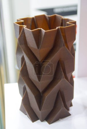 Kunstobjekt Vase auf 3D-Drucker aus geschmolzenem braunem Kunststoff mit Zusatz Kaffeemüll gedruckt. Modell aus Kunststoff mit abgebranntem Kaffee per 3D-Drucker. Additive progressive Technologie 3D-Druck-Recycling