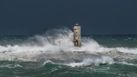 Foto de El faro de la mangarche de calasetta en el sur de Cerdeña sumergido por las olas de un mar tempestuoso - Imagen libre de derechos