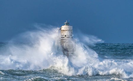 Foto de El faro de la mangarche de calasetta en el sur de Cerdeña sumergido por las olas de un mar tempestuoso - Imagen libre de derechos