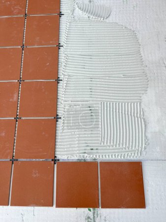 Photo for Worker spreads the cement glue before applying the ceramic tiles - Royalty Free Image