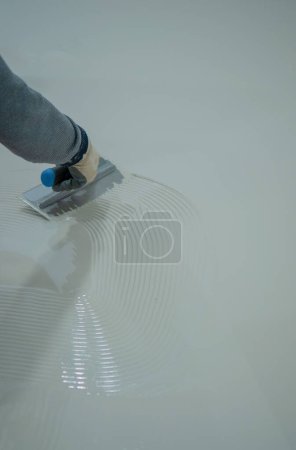 Foto de Trabajador pintura resina de poliuretano blanco sobre piso de hormigón - Imagen libre de derechos