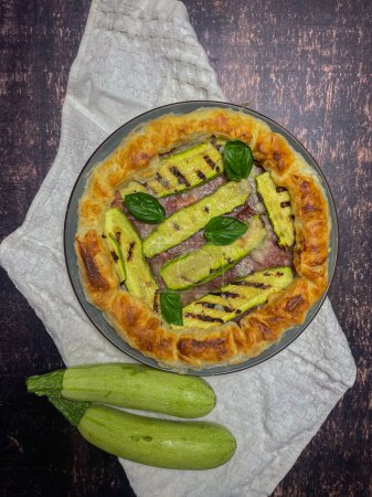 Foto de Pastel salado con calabacines y albahaca en un plato redondo - Imagen libre de derechos