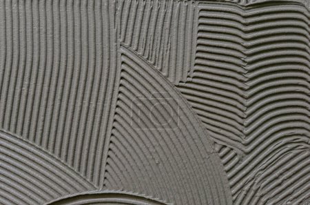 Textura adhesivo cementoso aplicado al suelo listo para recibir la baldosa cerámica