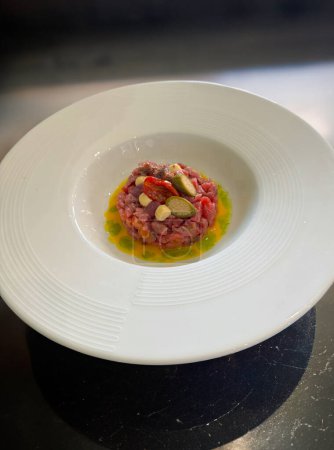 Modern style gourmet raw beef fillet tartare with cappei egg and dried tomato
