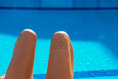 Foto de Piernas dobladas en las rodillas primer plano contra el fondo de azul bassin vacaciones turísticas - Imagen libre de derechos