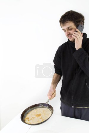 Photo for Dad cooks and talking on the phone - Royalty Free Image