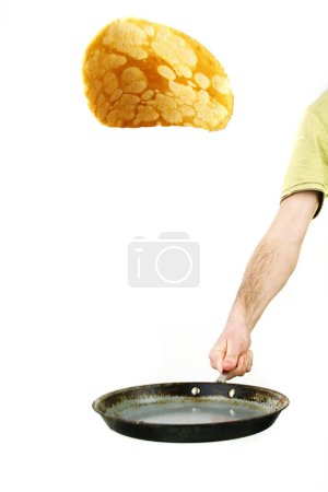 flip a pancake in a frying pan