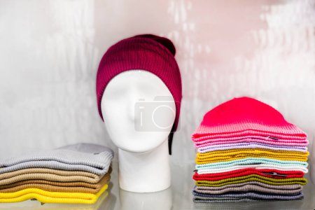Photo for Beautifully folded knitted multi-colored woolen hats on display. wardrobe - Royalty Free Image