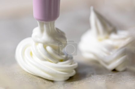 Photo for Classic white meringue lined with foil before baking. Festive mood - Royalty Free Image
