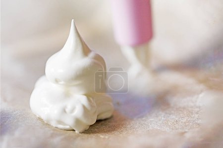 Foto de Preparar merengue clásico con una jeringa de pastelería en casa. Humor festivo - Imagen libre de derechos