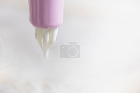 Foto de Gota de merengue en la punta de una jeringa de pastelería. Cocinar merengue clásico. - Imagen libre de derechos