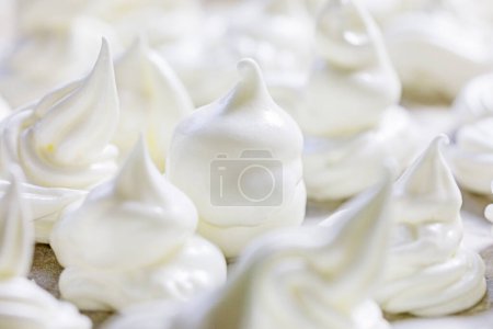 Foto de Primer plano del merengue blanco clásico presentado en papel de aluminio antes de hornear. Humor festivo - Imagen libre de derechos