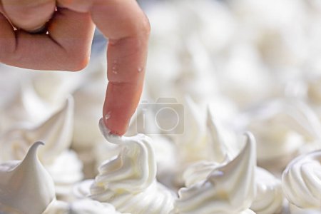 Foto de Dedo índice del niño prueba el merengue que aún no se ha colocado en el horno. - Imagen libre de derechos